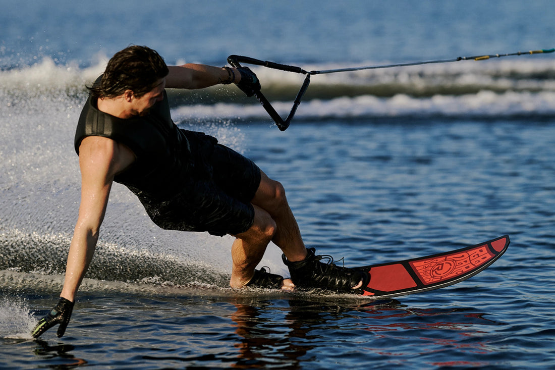Slalom water skier carving hard on a red ski