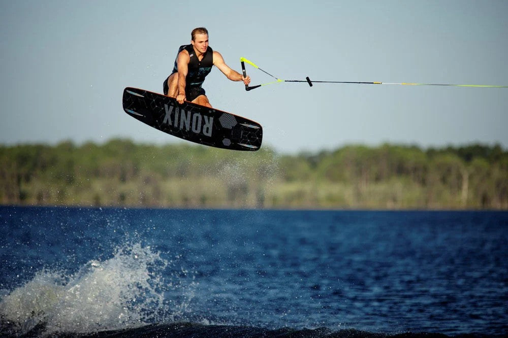 Wakeboarder mid-air off the wake behind a boat